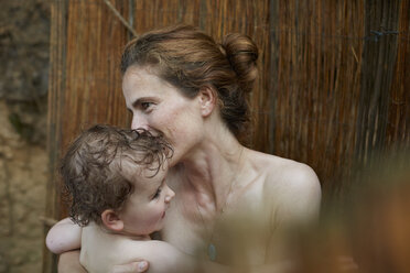 Mother and little daughter taking a shower outdoors - AMEF00045