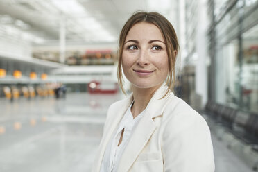 Porträt einer lächelnden jungen Geschäftsfrau auf dem Flughafen - PNEF01370