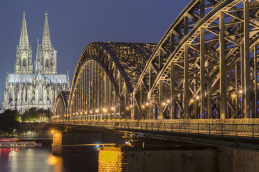 Deutschland, Köln, Blick auf den beleuchteten Kölner Dom mit der Hohenzollernbrücke im Vordergund - MKFF00474