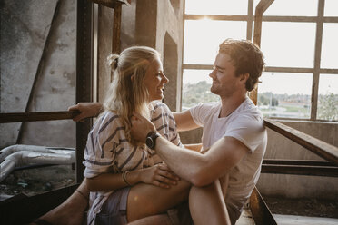 Happy young couple cuddling in an old building - LHPF00498