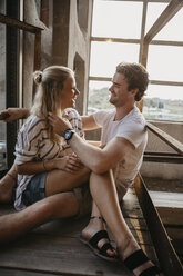 Glückliches junges Paar kuschelnd in einem alten Gebäude - LHPF00499
