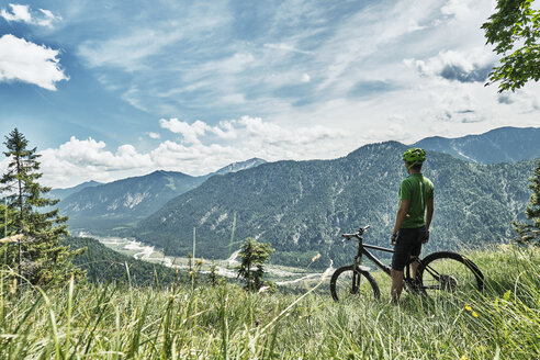 Deutschland, Bayern, Isartal, Karwendelgebirge, Mountainbiker auf Tour mit Pause auf Almwiese - WFF00073