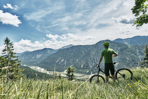 Deutschland, Bayern, Isartal, Karwendelgebirge, Mountainbiker auf Tour mit Pause auf Almwiese - WFF00074