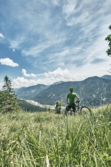 Deutschland, Bayern, Isartal, Karwendelgebirge, Mountainbiker auf Tour mit Pause auf Almwiese - WFF00077