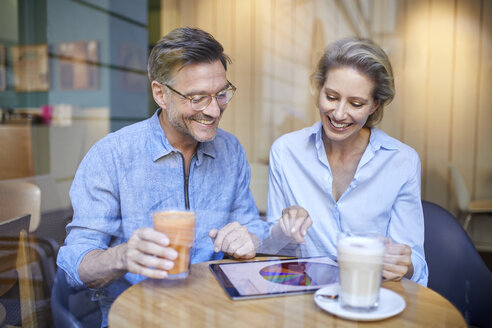 Glückliche Frau und Mann mit Tablet in einem Café - PNEF01385