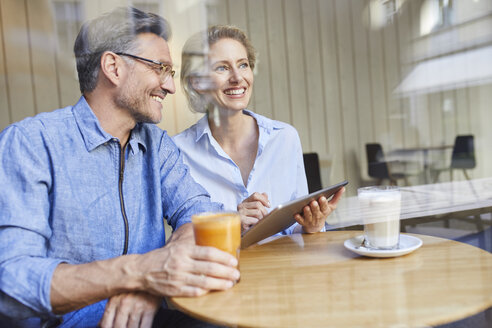 Glückliche Frau und Mann mit Tablet in einem Café - PNEF01387
