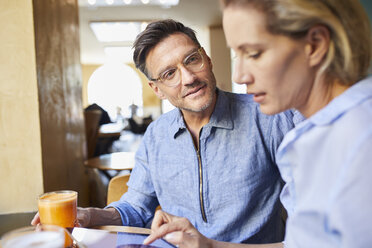 Mann und Frau mit Tablet in einem Cafe - PNEF01389