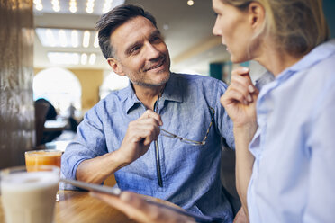 Smiling man and woman with tablet in a cafe - PNEF01393