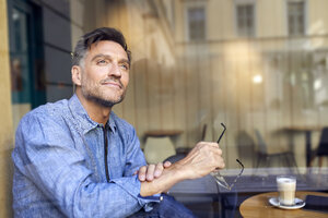 Porträt eines Mannes hinter einer Fensterscheibe in einem Cafe - PNEF01407