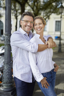 Porträt eines glücklichen Paares, das sich in der Stadt umarmt - PNEF01442