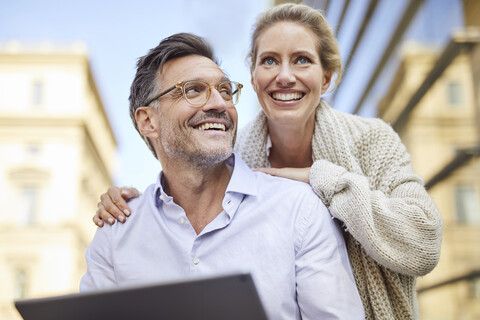 Happy couple using tablet in the city stock photo