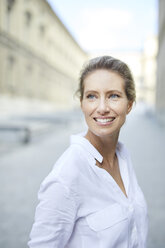 Portrait of smiling woman wearing white shirt in the city - PNEF01453