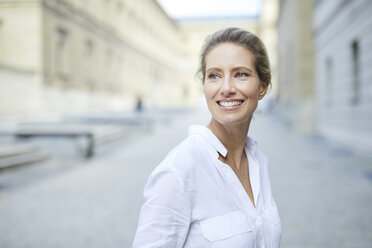 Portrait of smiling woman wearing white shirt in the city - PNEF01455