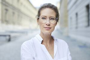 Porträt einer selbstbewussten Frau mit Brille und weißem Hemd in der Stadt - PNEF01456