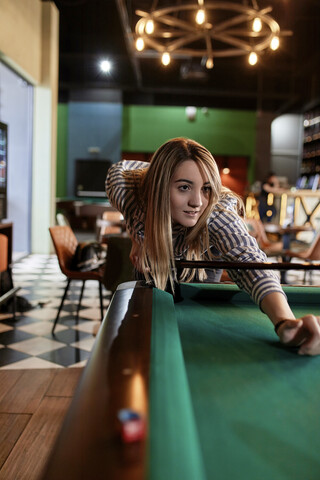 Junge Frau spielt Billard, lizenzfreies Stockfoto