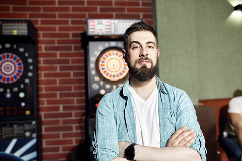 Porträt eines selbstbewussten Mannes an der Dartscheibe, lizenzfreies Stockfoto