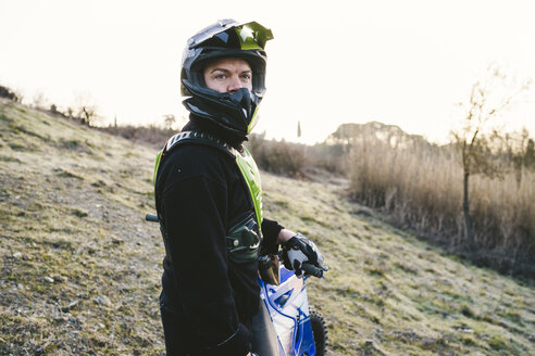 Porträt eines Motocross-Fahrers bei Sonnenuntergang - FBAF00331