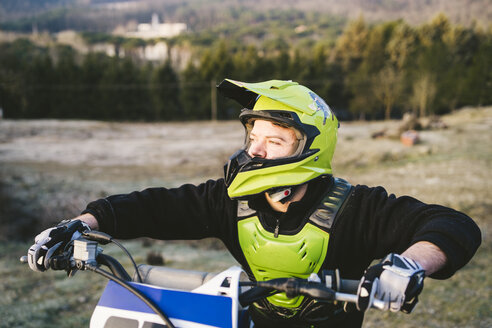 Porträt eines Motocross-Fahrers bei Sonnenuntergang - FBAF00333