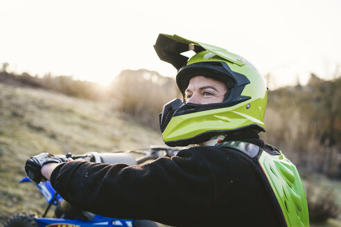 Porträt eines Motocross-Fahrers bei Sonnenuntergang - FBAF00334