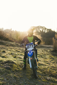 Motocross-Fahrer auf der Rennstrecke bei Sonnenuntergang - FBAF00337