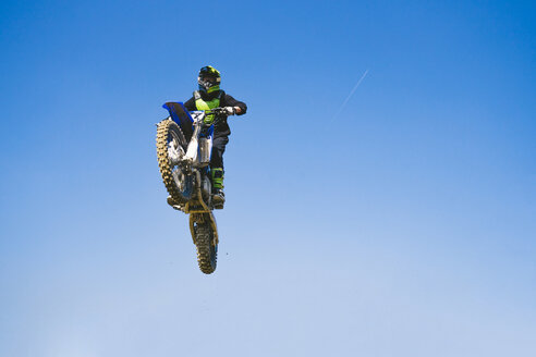 Motocross-Fahrer springt in blauen Himmel - FBAF00358