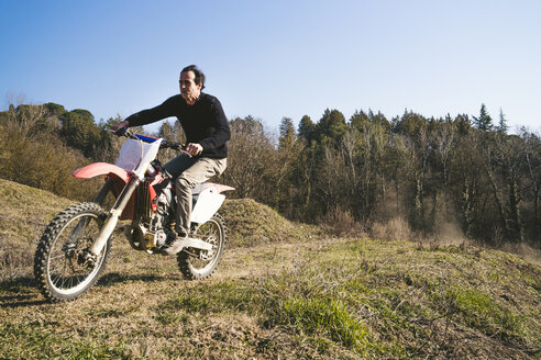 Senior-Motocross-Fahrer fährt auf der Rennstrecke - FBAF00365