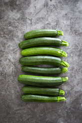 Courgettes in a row, grey background - GIOF05859