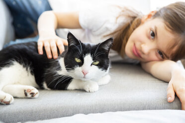 Little girl lying on couch with cat - LVF07928