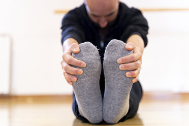 Ballet dancer stretching in ballet studio - FMOF00456