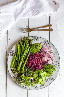 Plate of springtime salad with green asparagus, red quinoa, avocado, red radishes, cucumber and sprouts - SARF04204