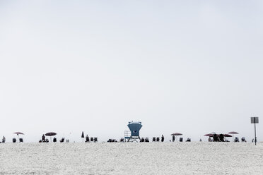 Lifeguard tower and people relaxing under umbrellas on sunny beach, San Diego, California, USA - FSIF03783