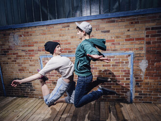 Modern dancers performing against brick wall - FSIF03810