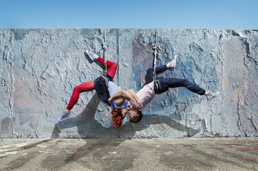 Modern aerialist dancers kissing, hanging upside-down - FSIF03824