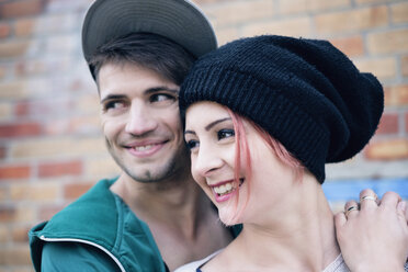 Lächelndes, zärtliches junges Paar schaut weg - FSIF03826