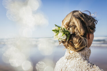 Blonde Braut mit Blumen im Haar am sonnigen Strand - FSIF03858