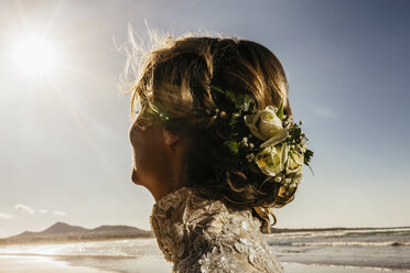 Braut mit Blumen im Haar am sonnigen Meeresstrand - FSIF03859