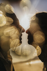 Goldenes Licht beleuchtet Silhouette Profil des Paares küssen - FSIF03861