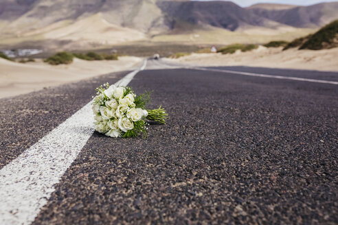 Brautstrauß mit Rosen, die auf einer abgelegenen Straße liegen - FSIF03884