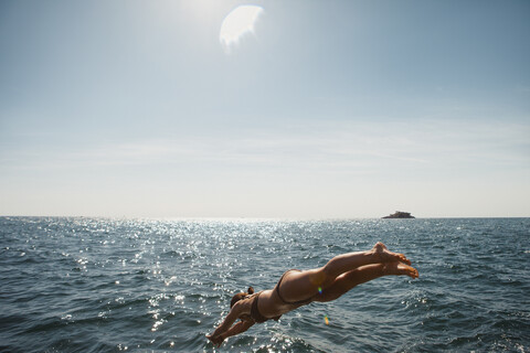 Frau taucht ins sonnige blaue Meer, Rovinj, Kroatien, lizenzfreies Stockfoto