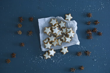 Cinnamon stars, star anise and pine cones on blue ground - ASF06356