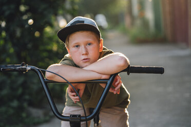 Porträt eines Jungen mit BMX-Fahrrad auf der Straße - VPIF01200