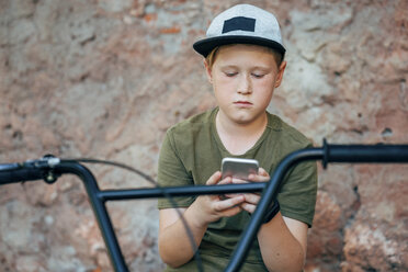 Junge mit BMX-Fahrrad, der ein Mobiltelefon benutzt - VPIF01202