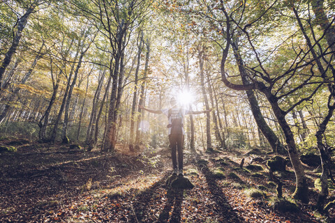 Spain, Navarra, Irati Forest, young man standing in lush forest with outstretched arms stock photo