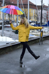 Dänemark, Kopenhagen, glückliche Frau mit buntem Regenschirm am Stadthafen - ECPF00637