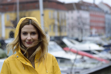 Dänemark, Kopenhagen, Porträt einer lächelnden Frau am Stadthafen bei regnerischem Wetter - ECPF00641