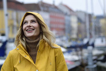 Dänemark, Kopenhagen, Porträt einer glücklichen Frau am Stadthafen bei regnerischem Wetter - ECPF00643