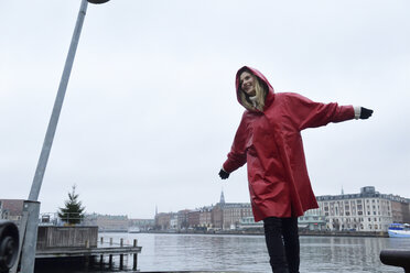 Dänemark, Kopenhagen, glückliche Frau am Wasser bei Regenwetter - ECPF00671