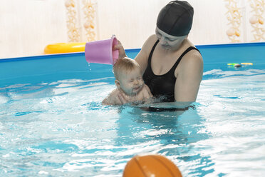 Babyschwimmen, Mutter mit Tochter im Schwimmbad, Mutter gießt Wasser über den Kopf - VGF00263