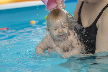 Babyschwimmen, Mutter mit Tochter im Schwimmbad, Mutter gießt Wasser über den Kopf - VGF00264
