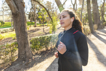 Junge Frau joggt im Park - WPEF01430